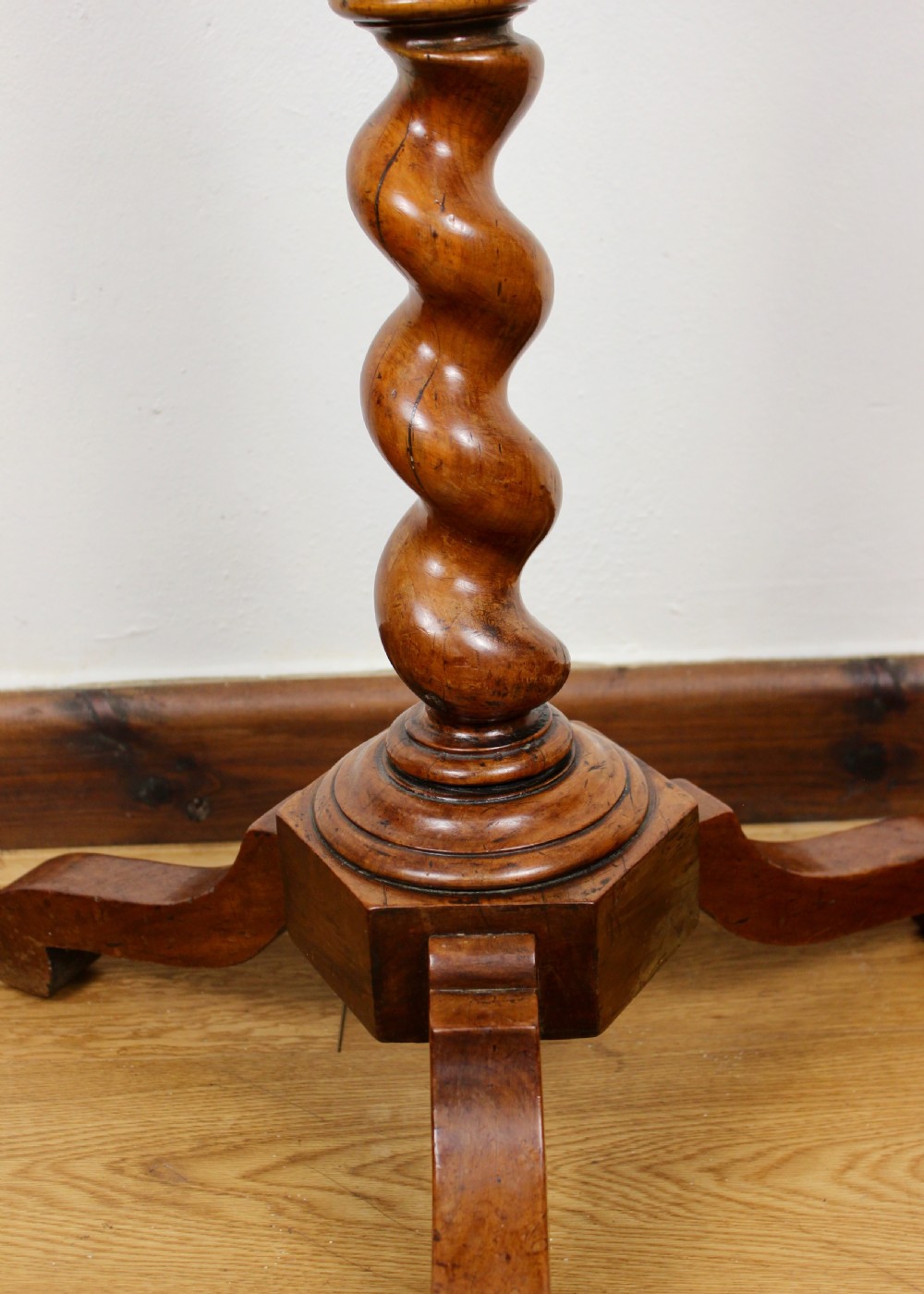 An antique William and Mary walnut candle stand featuring an octagonal top, a central barley-twist column, and a tripod base. View IV