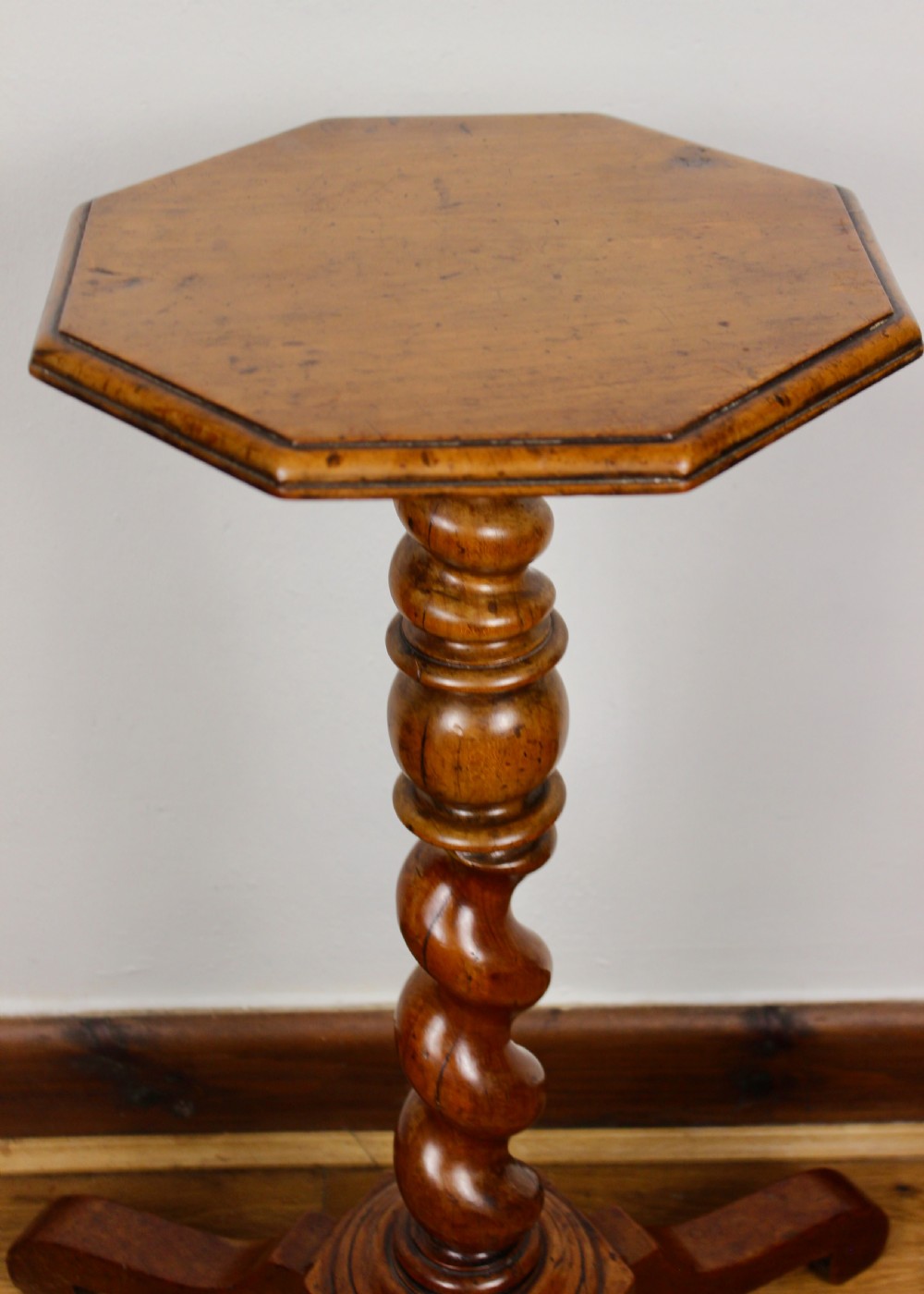 An antique William and Mary walnut candle stand featuring an octagonal top, a central barley-twist column, and a tripod base. View VIII