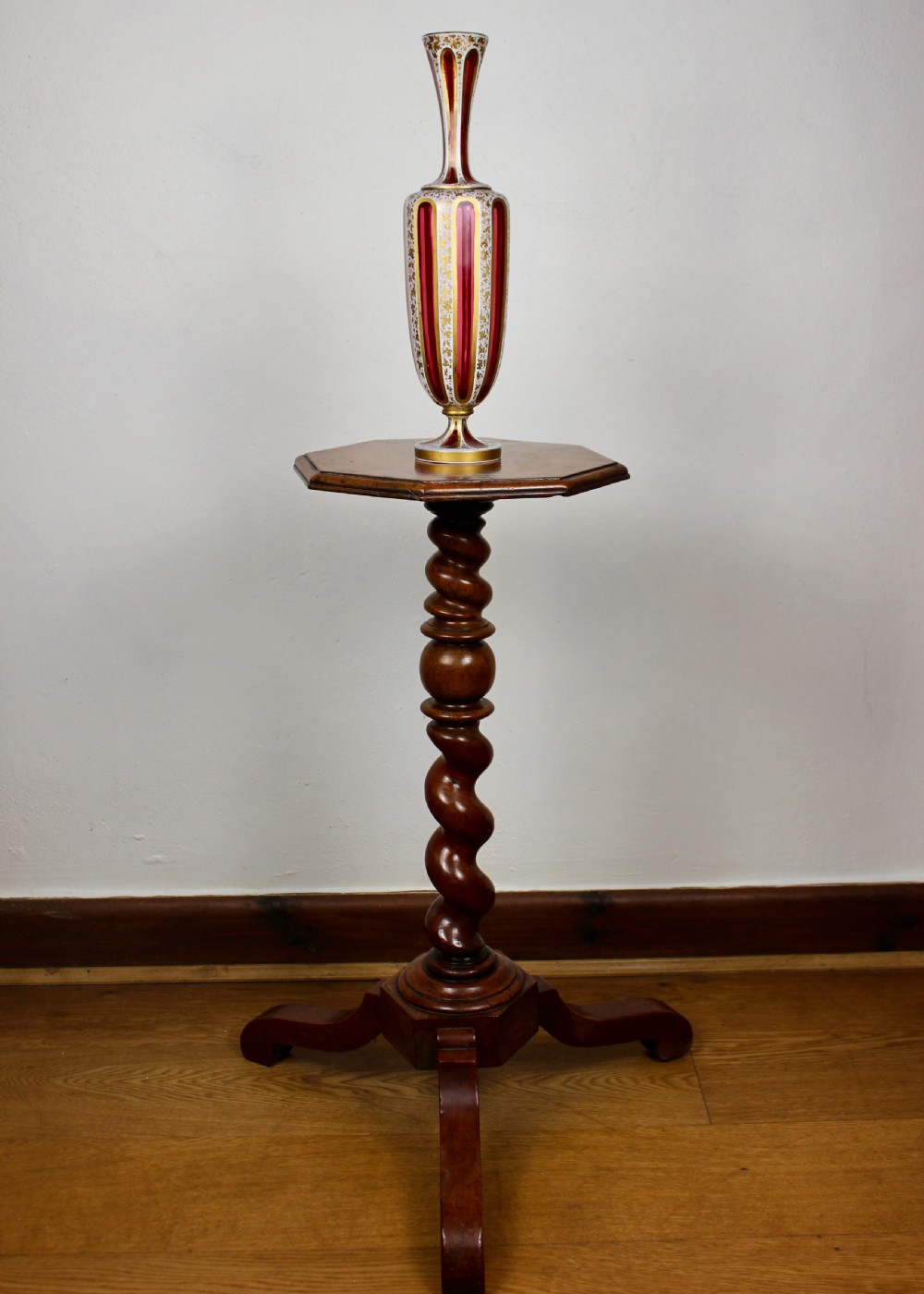 A nineteenth-century Bohemian ruby glass vase featuring white cased glass panels cut to clear with intricate gilt floral ornamentation. View II