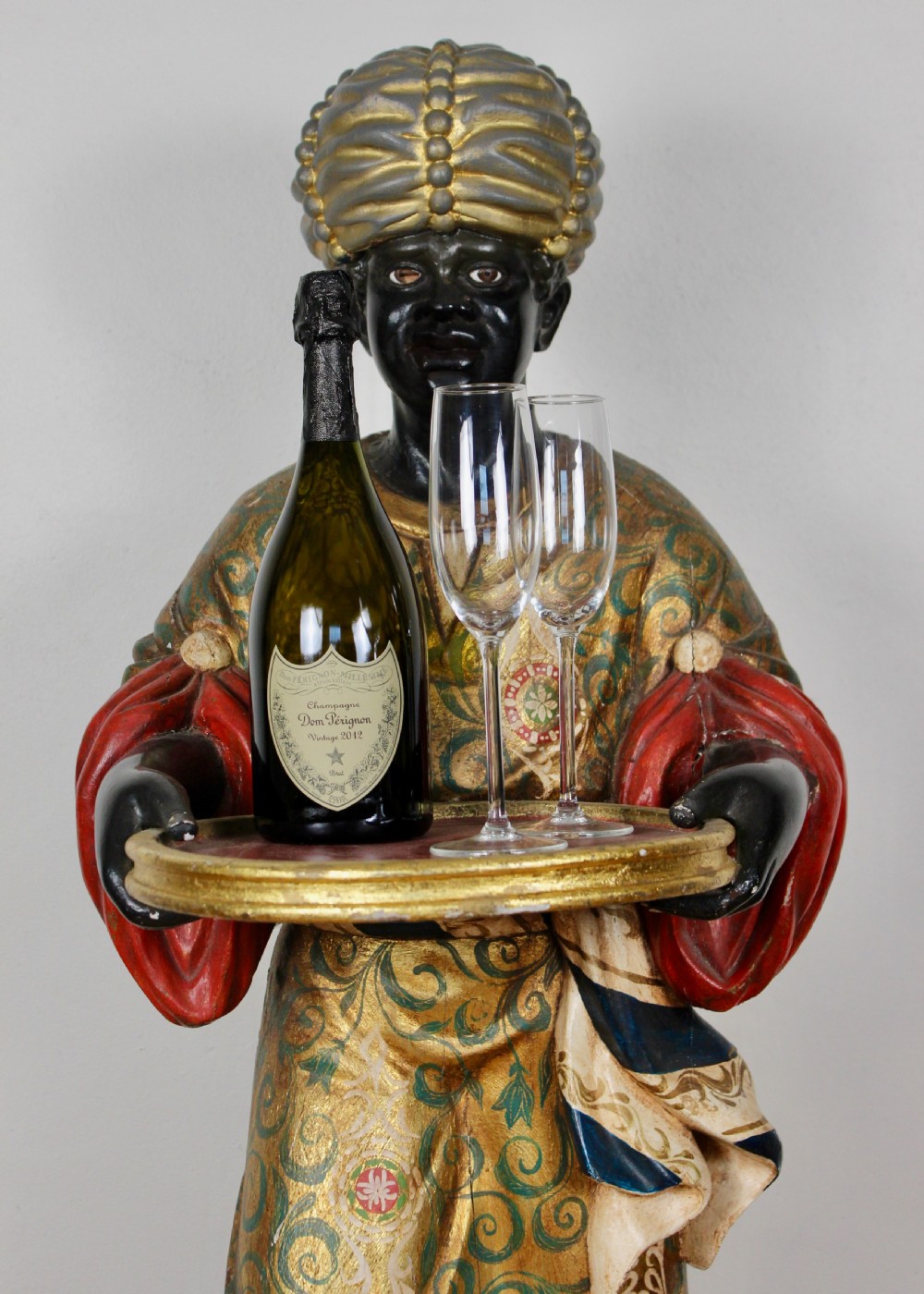A carved wooden standing Venetian waiter figure wearing a decorated gold tunic and turban while holding a tray on a carved base. View III