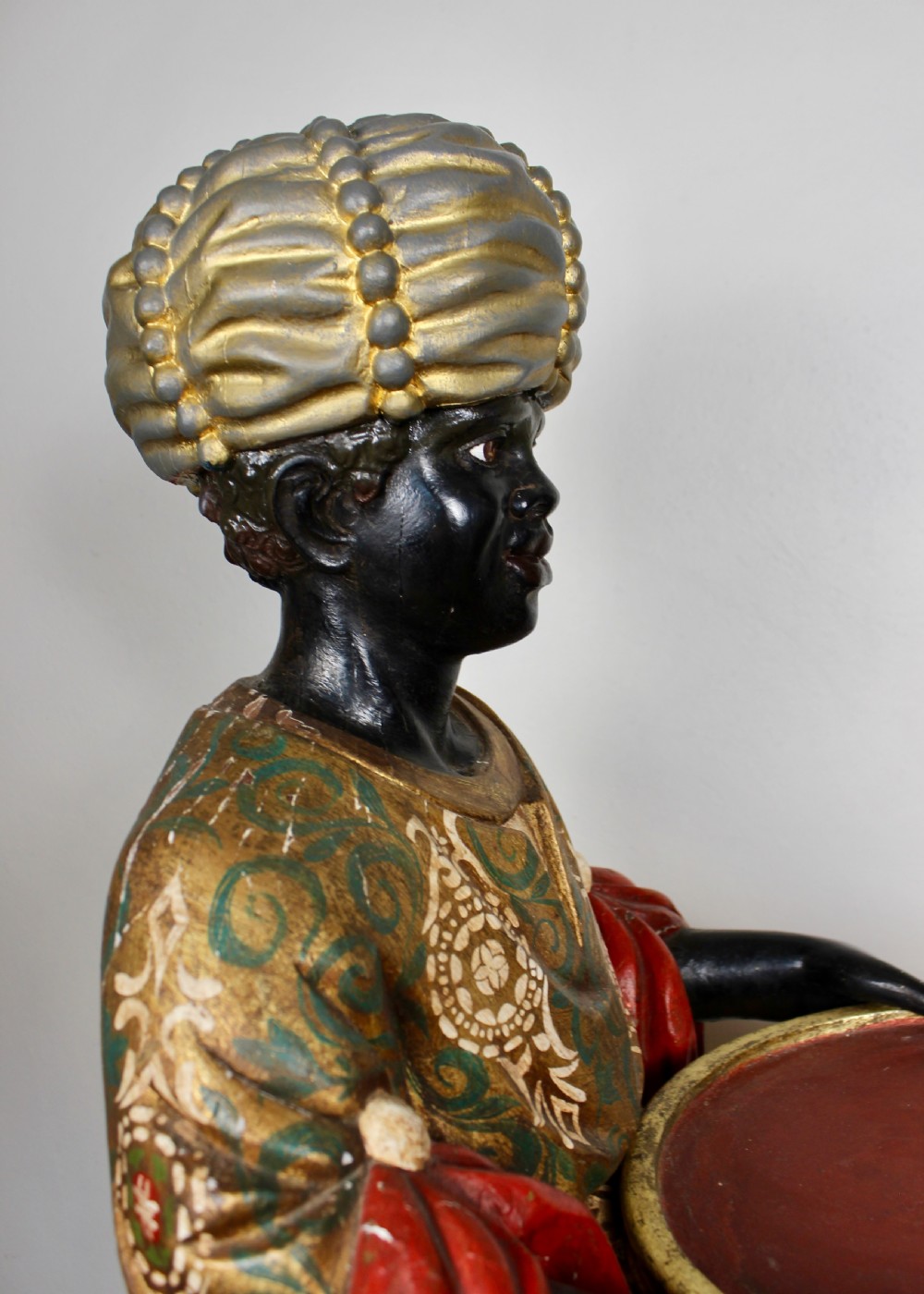 A carved wooden standing Venetian waiter figure wearing a decorated gold tunic and turban while holding a tray on a carved base. View X