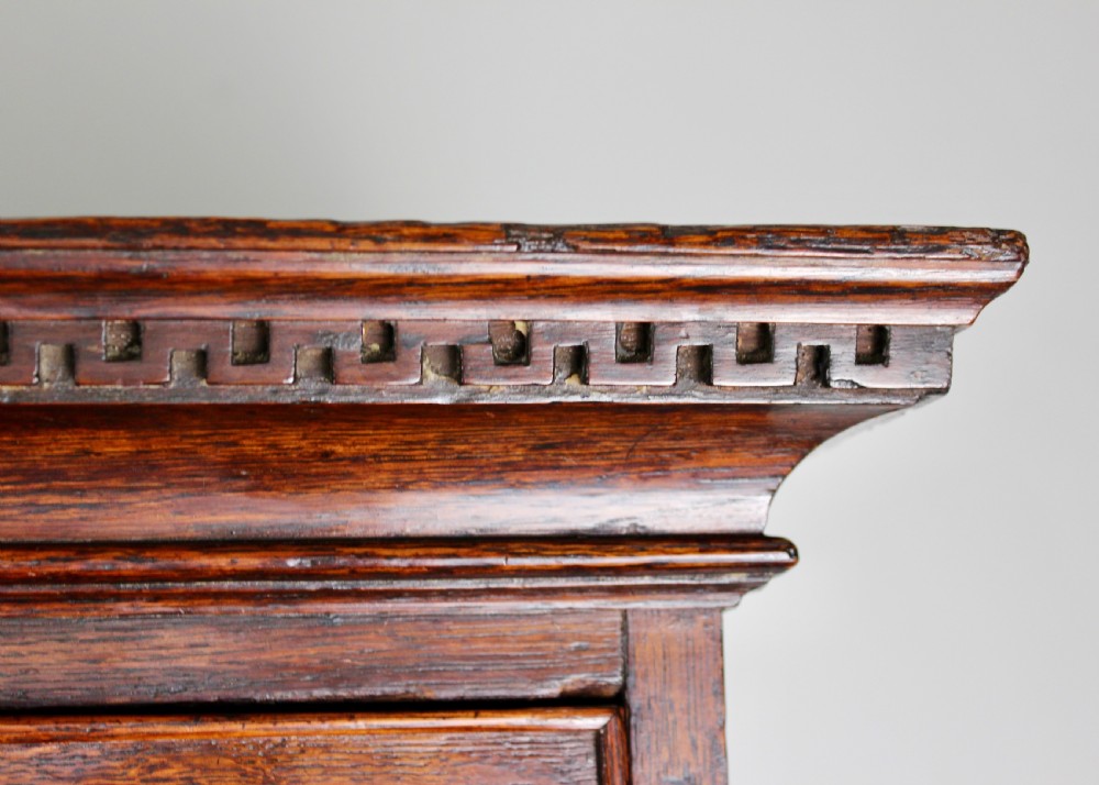 A tall George III dark oak chest-on-chest featuring two short over five long graduated drawers adorned with ornate brass handles and supported on ogee bracket feet. View VII