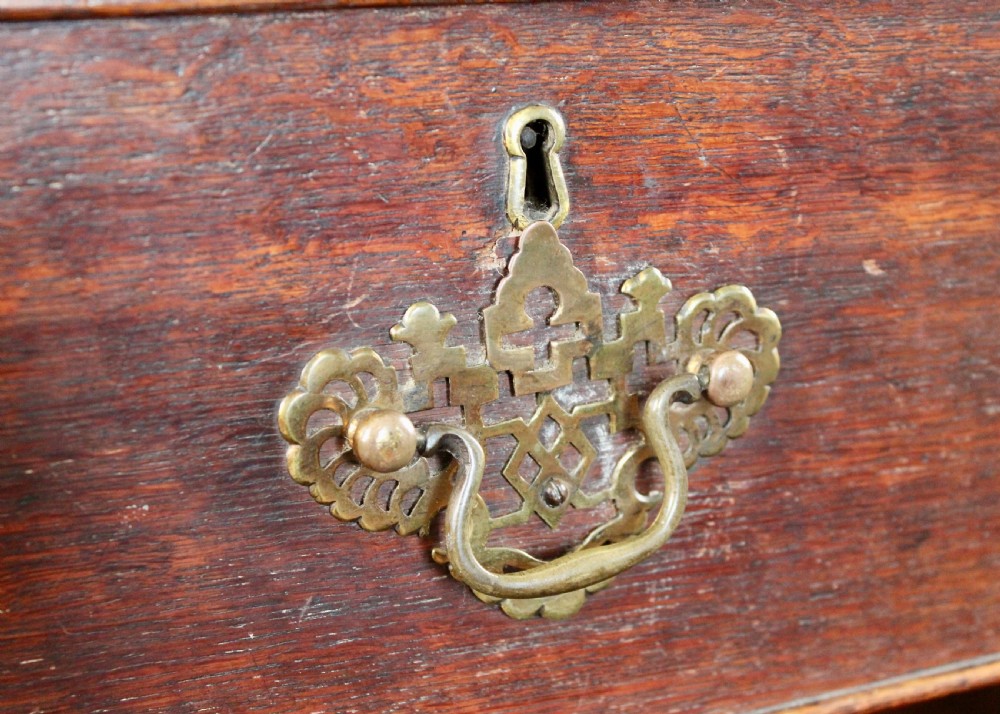 A tall George III dark oak chest-on-chest featuring two short over five long graduated drawers adorned with ornate brass handles and supported on ogee bracket feet. View VIII