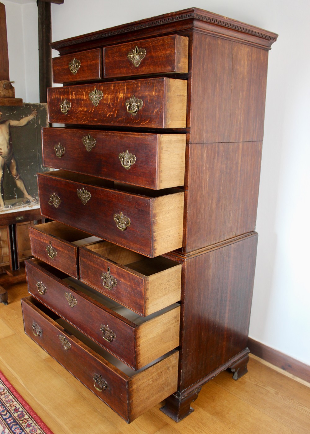 A tall George III dark oak chest-on-chest featuring two short over five long graduated drawers adorned with ornate brass handles and supported on ogee bracket feet. View XI