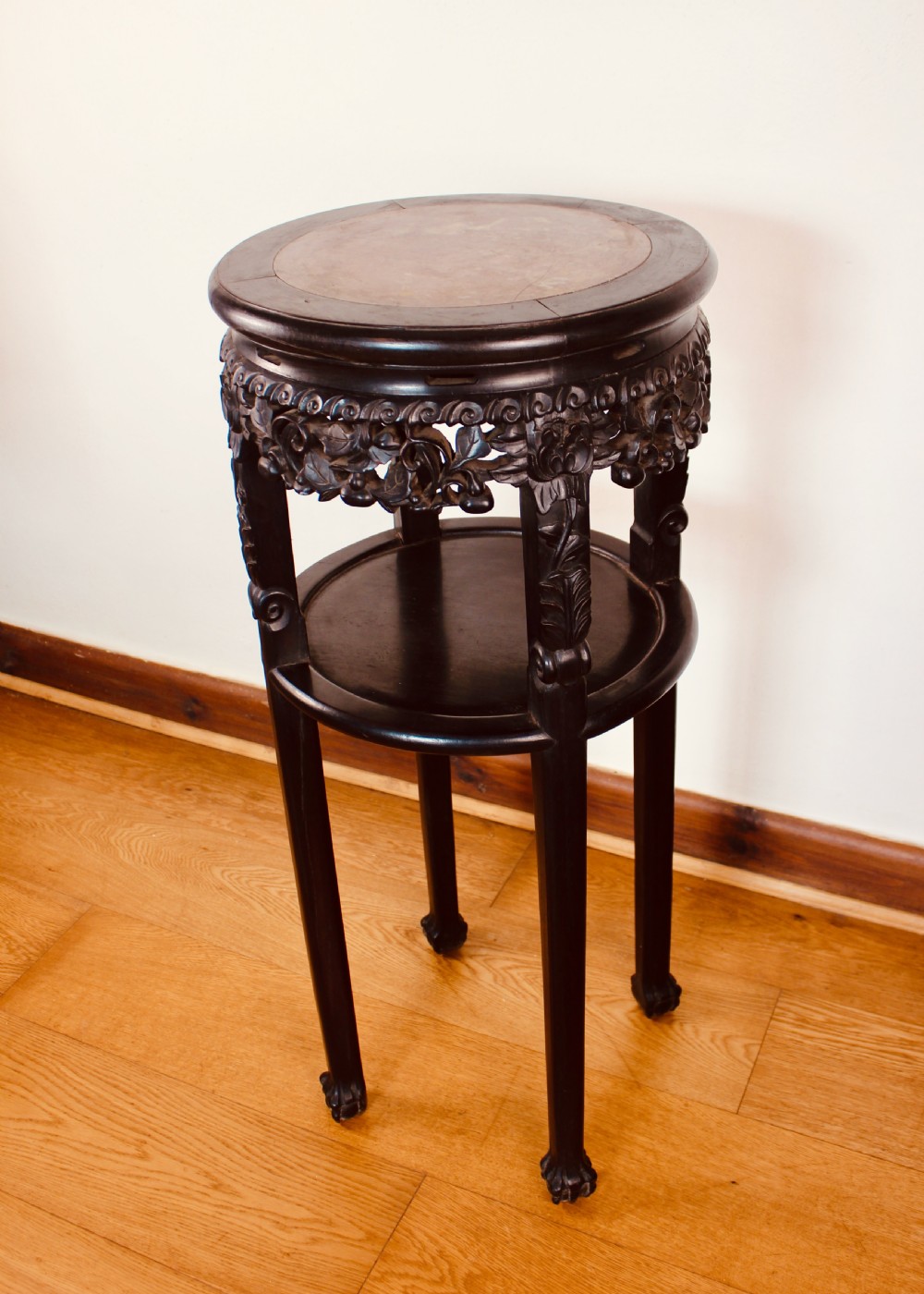 A tall dark hardwood circular jardiniere stand featuring an inset marble top, a pierced carved frieze, a lower circular undertier, and four slender legs. View IV