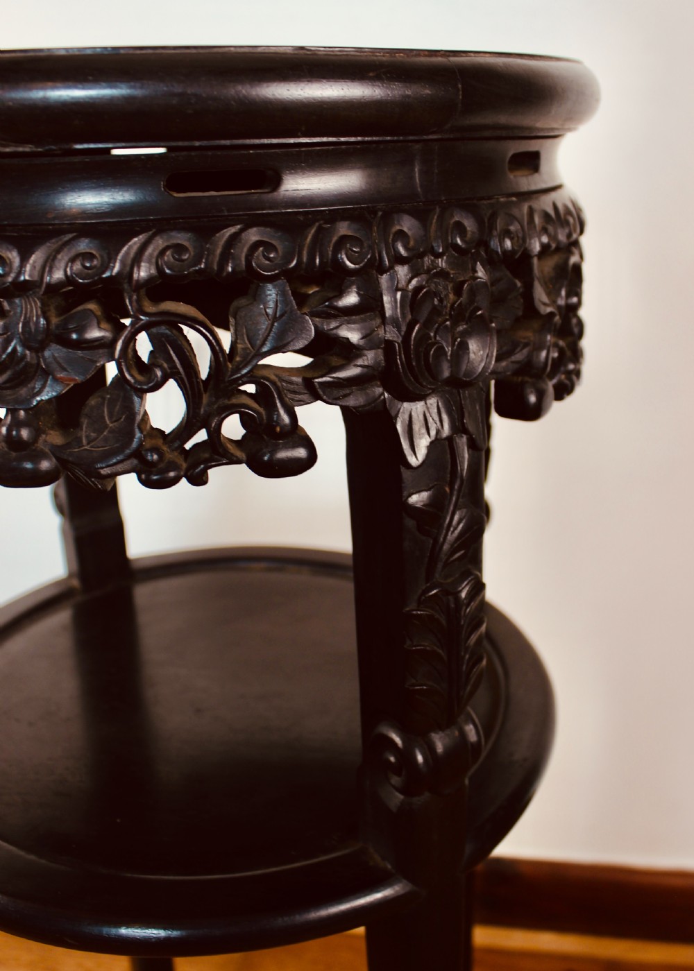 A tall dark hardwood circular jardiniere stand featuring an inset marble top, a pierced carved frieze, a lower circular undertier, and four slender legs. View VI