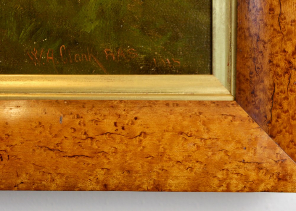 An Edwardian oil painting depicts a brown cow standing in a grassy field before trees, presented within a wide figured maple wood frame with a gold slip. View IV