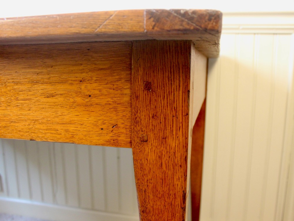 A 19th-century French provincial oak farmhouse table featuring a rectangular plank top, a single frieze drawer with a wooden knob, and four tapered square legs. View VI