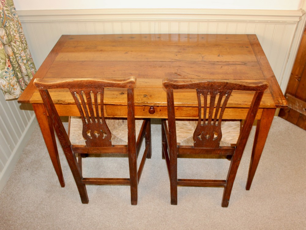 A 19th-century French provincial oak farmhouse table featuring a rectangular plank top, a single frieze drawer with a wooden knob, and four tapered square legs. View IX