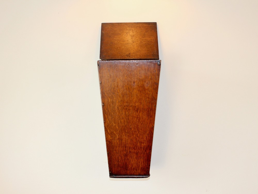 A George III tapered wall-hanging candle box crafted from warm brown oak with an arched crest panel and a top lid. View IV