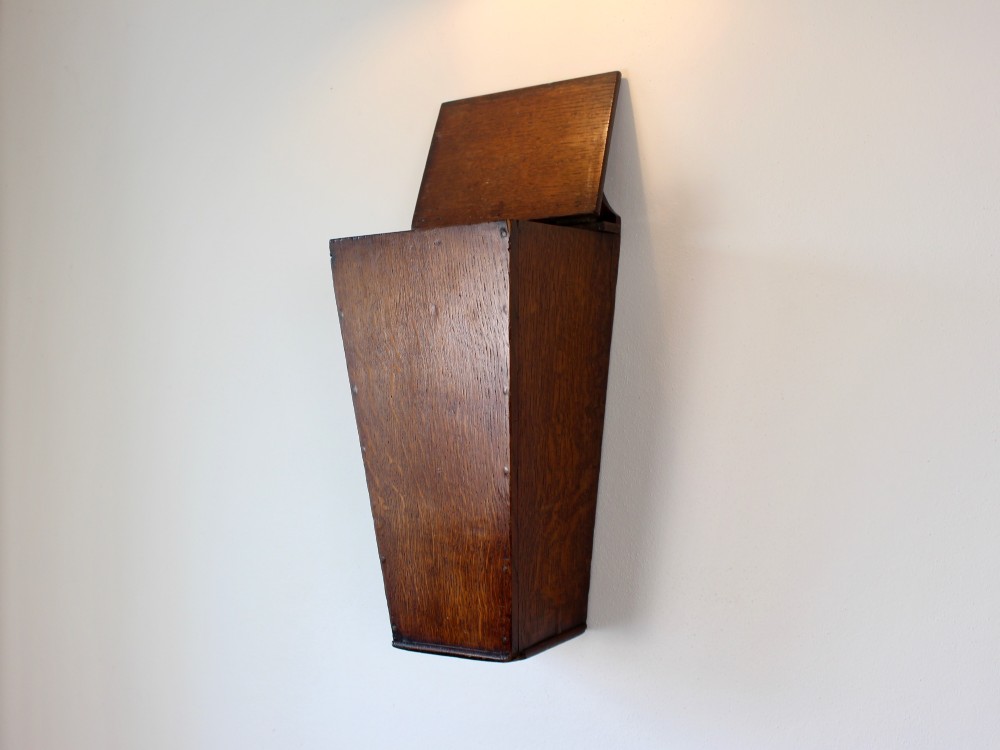 A George III tapered wall-hanging candle box crafted from warm brown oak with an arched crest panel and a top lid. View V