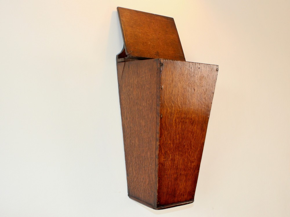A George III tapered wall-hanging candle box crafted from warm brown oak with an arched crest panel and a top lid. View VI