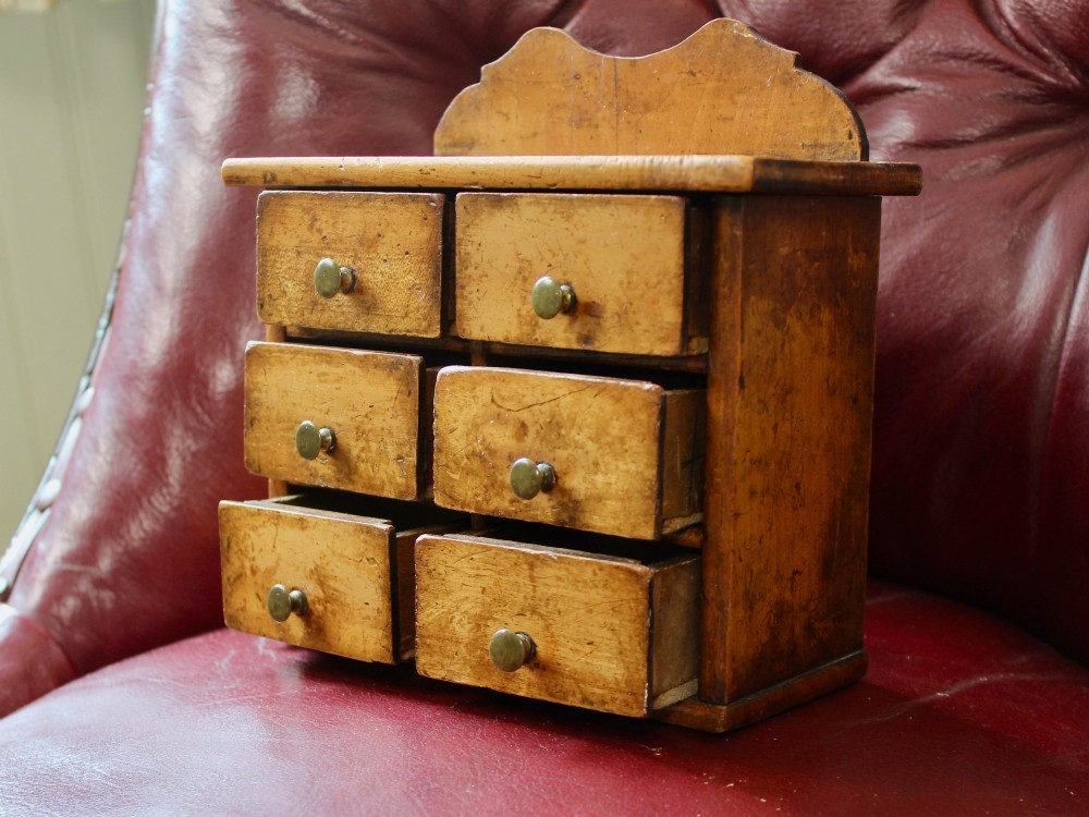 A small 19th-century fruitwood spice chest featuring six individual drawers with small brass knobs and a shaped back gallery. View III