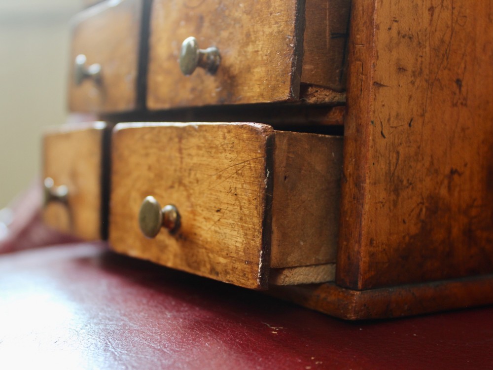 A small 19th-century fruitwood spice chest featuring six individual drawers with small brass knobs and a shaped back gallery. View IV
