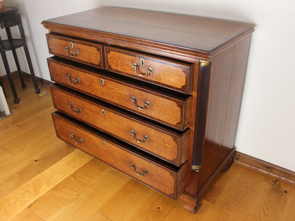 An 18th-century Georgian oak chest of drawers with mahogany crossbanding, brass handles, fluted corner columns, and bracket feet. View III