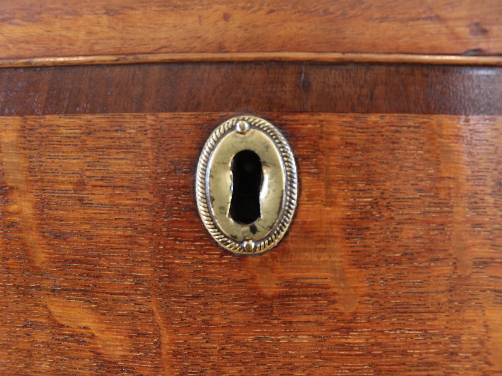 An 18th-century Georgian oak chest of drawers with mahogany crossbanding, brass handles, fluted corner columns, and bracket feet. View VII