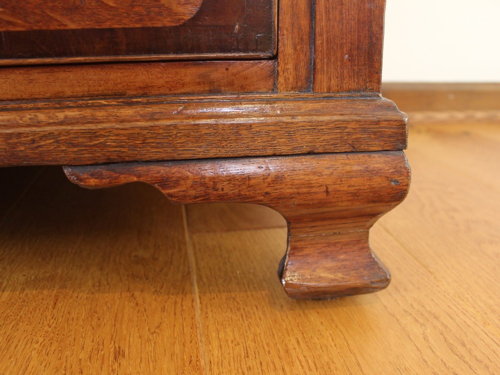 An 18th-century Georgian oak chest of drawers with mahogany crossbanding, brass handles, fluted corner columns, and bracket feet. View VIII