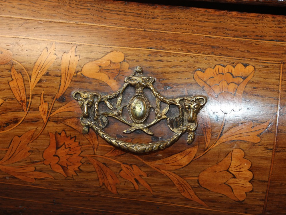 An eighteenth-century Dutch oak chest of drawers featuring a shaped bombe front, elaborate floral marquetry inlay, four graduated drawers with brass handles, and claw and ball feet. View XII