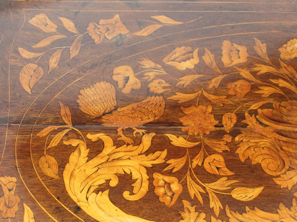 An eighteenth-century Dutch oak chest of drawers featuring a shaped bombe front, elaborate floral marquetry inlay, four graduated drawers with brass handles, and claw and ball feet. View XIV