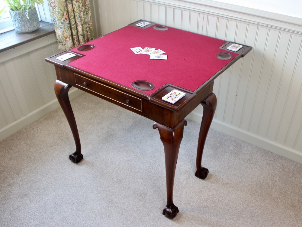 A George III mahogany fold-over card table featuring cabriole legs terminating in ball and claw feet alongside a central frieze drawer. View VI