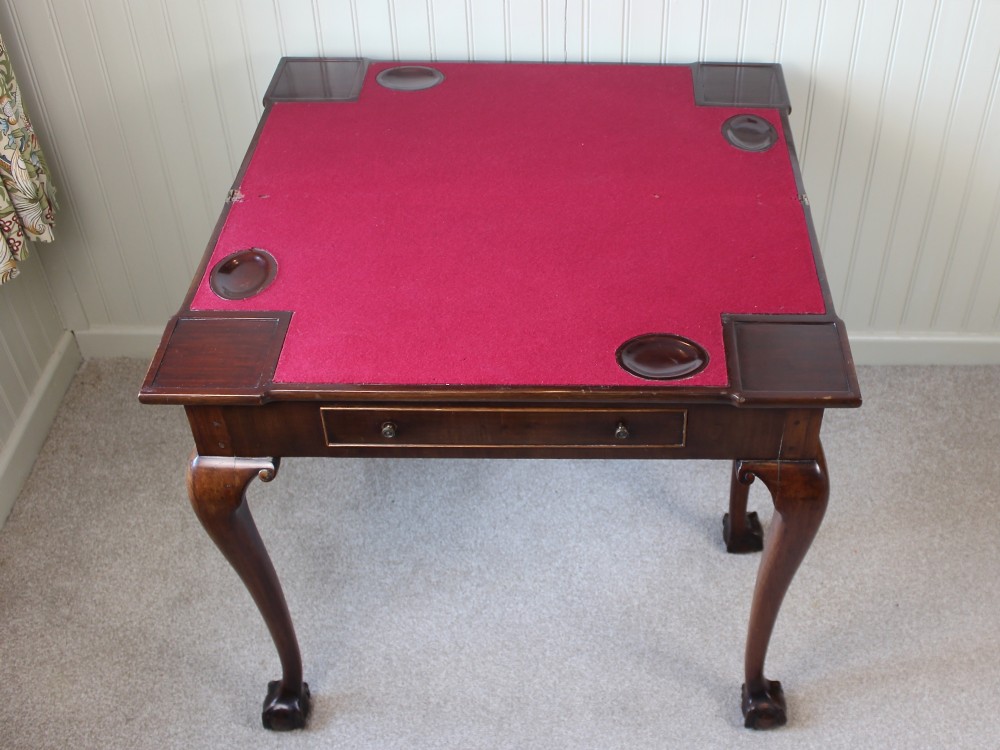 A George III mahogany fold-over card table featuring cabriole legs terminating in ball and claw feet alongside a central frieze drawer. View VIII