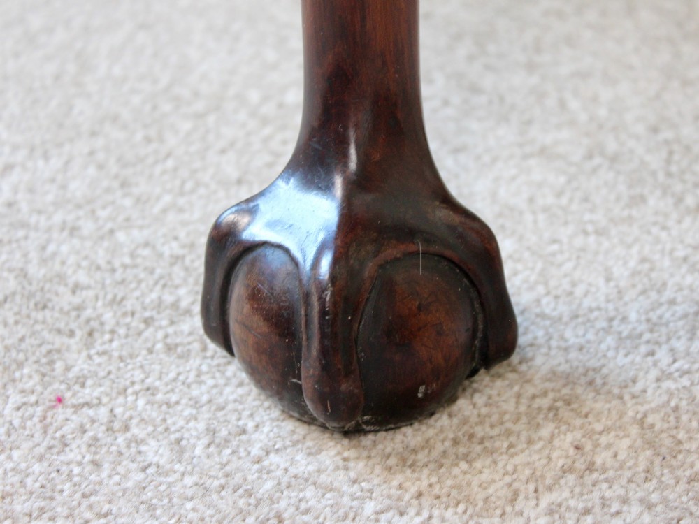 A George III mahogany fold-over card table featuring cabriole legs terminating in ball and claw feet alongside a central frieze drawer. View X