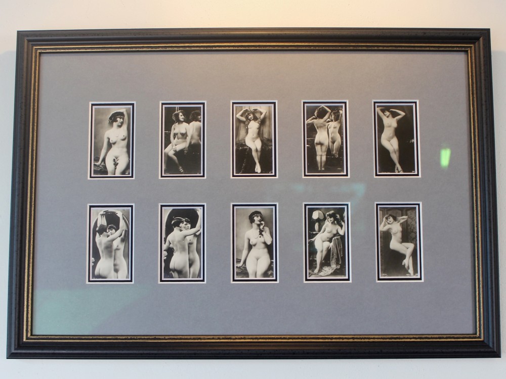 A dark frame displaying ten 1920s monochrome photographic prints of female nudes by Julian Mandel arranged in two rows against a grey mount. View III