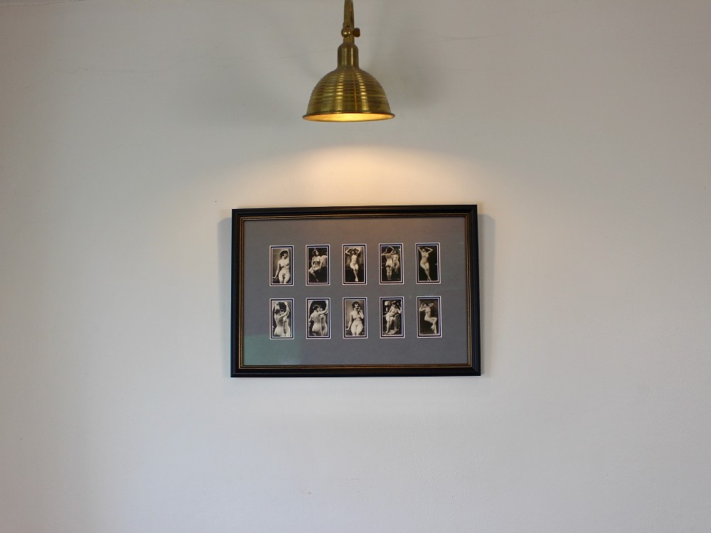 A dark frame displaying ten 1920s monochrome photographic prints of female nudes by Julian Mandel arranged in two rows against a grey mount. View IV
