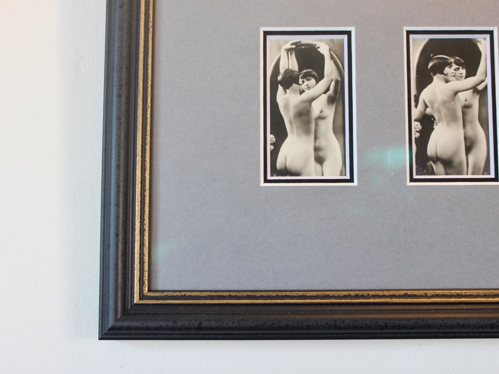 A dark frame displaying ten 1920s monochrome photographic prints of female nudes by Julian Mandel arranged in two rows against a grey mount. View V