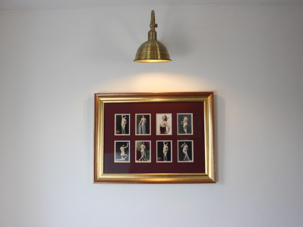 An array of eight 1920s hand-tinted female nude photographs mounted on a burgundy mat within a moulded gold frame. View II
