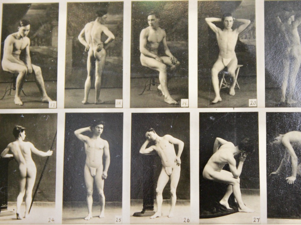 A framed 1920s monochrome photographic contact sheet displaying multiple male nude poses, mounted on burgundy card within a dark timber frame with gilt detailing. View IX