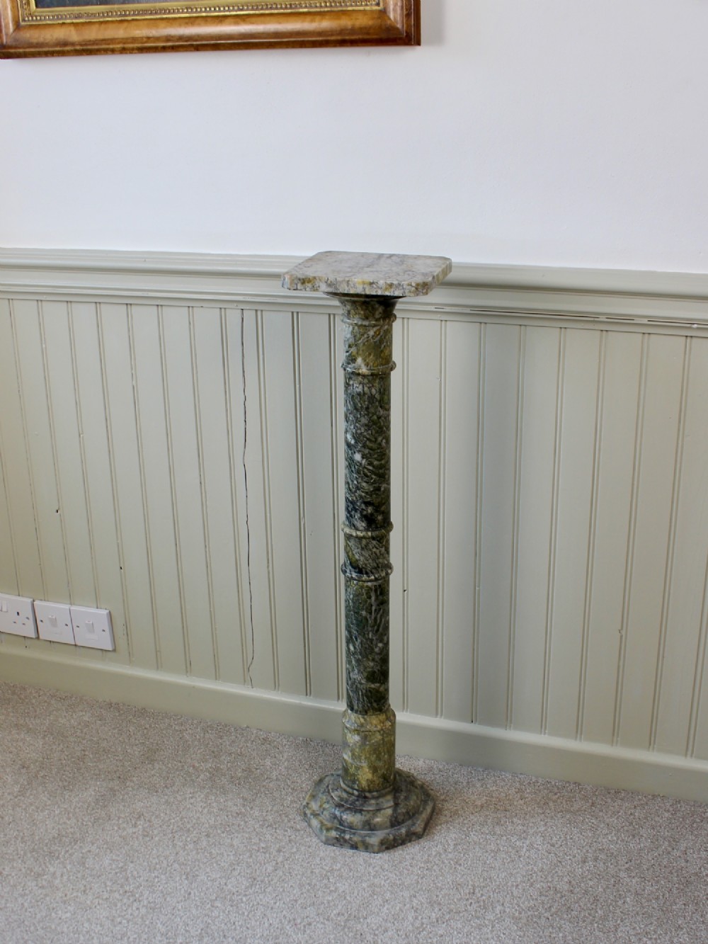 A tall Neoclassical carved green marble column pedestal featuring a square top capital, cylindrical shaft, and octagonal base. View II