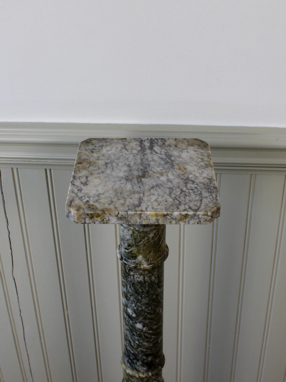 A tall Neoclassical carved green marble column pedestal featuring a square top capital, cylindrical shaft, and octagonal base. View III