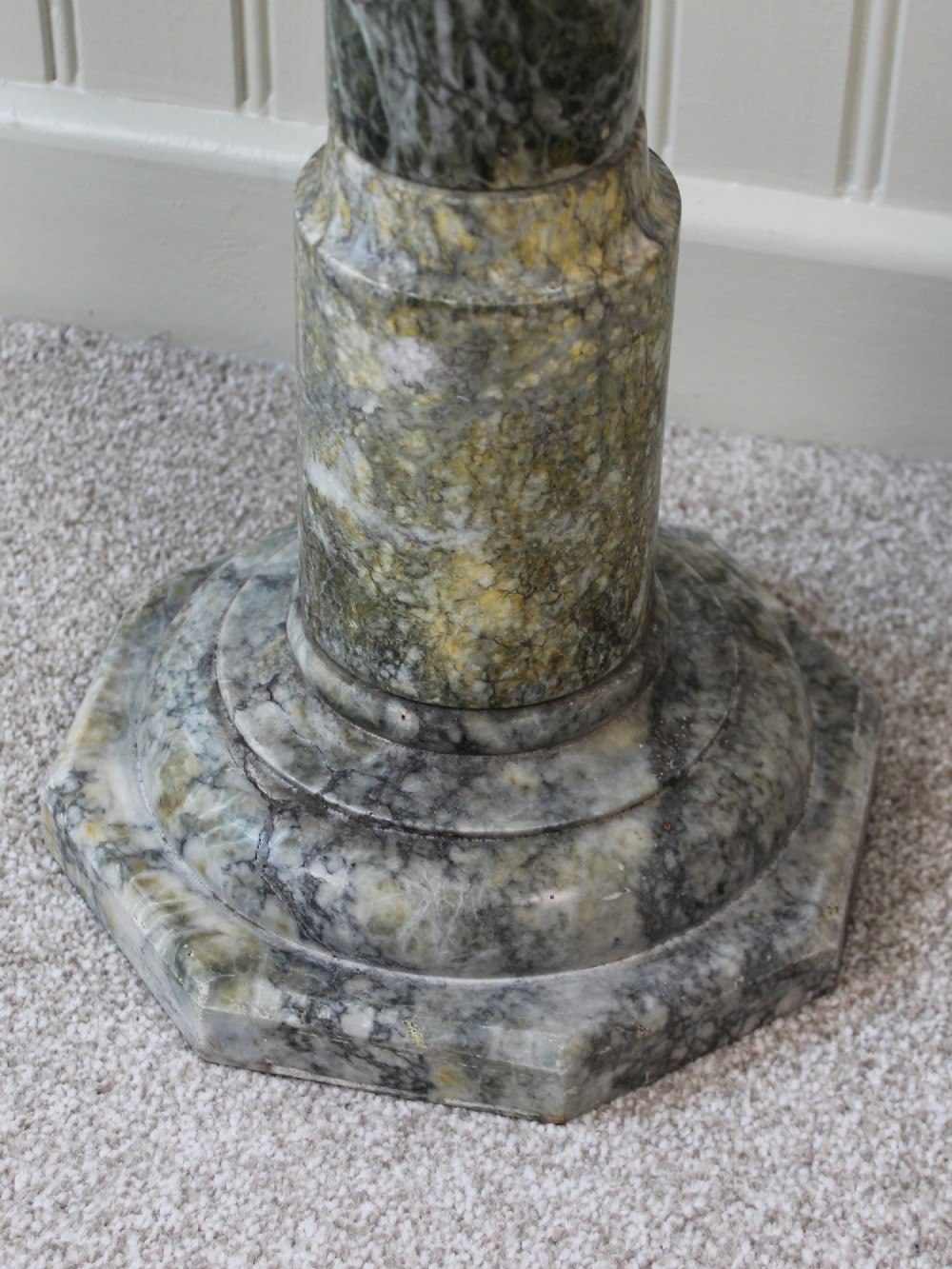 A tall Neoclassical carved green marble column pedestal featuring a square top capital, cylindrical shaft, and octagonal base. View IV