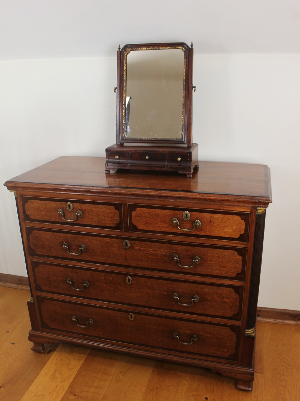 A George II mahogany dressing mirror featuring a swivel glass plate with a parcel-gilt frame resting on a three-drawer base. View II