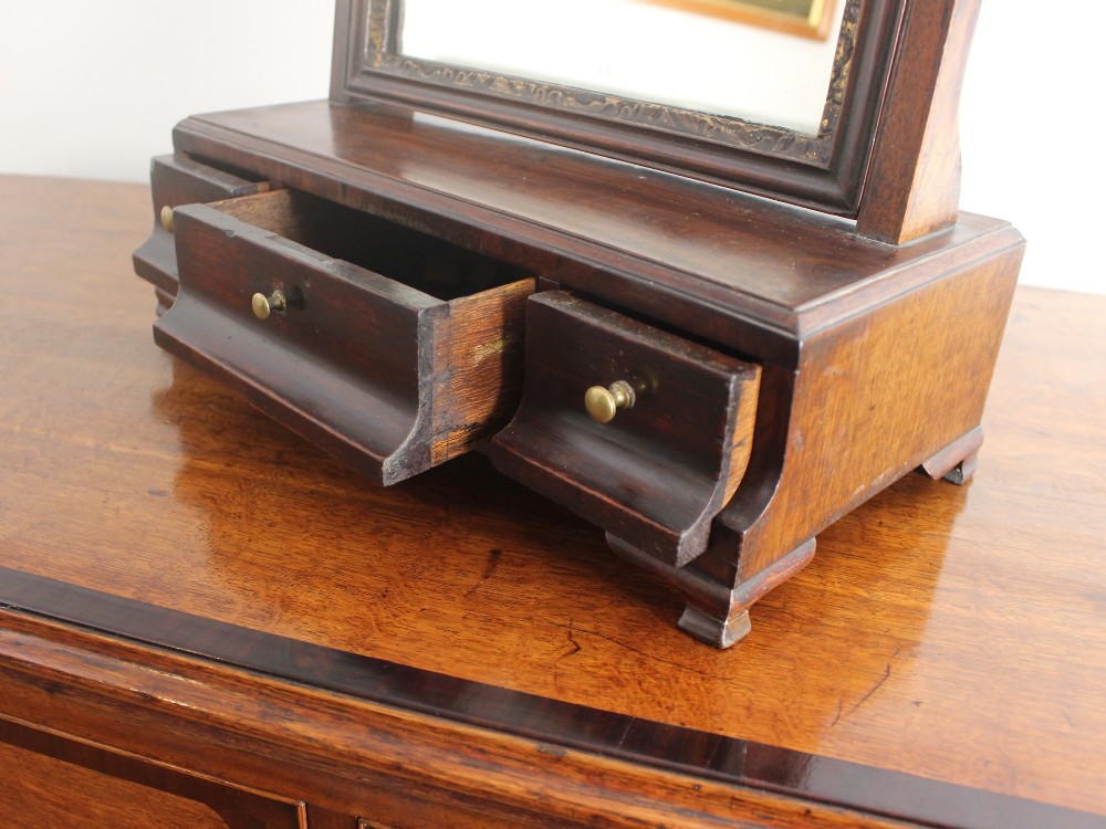A George II mahogany dressing mirror featuring a swivel glass plate with a parcel-gilt frame resting on a three-drawer base. View VII