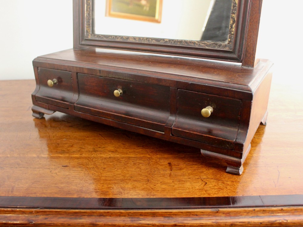 A George II mahogany dressing mirror featuring a swivel glass plate with a parcel-gilt frame resting on a three-drawer base. View VIII
