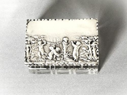 An Edwardian rectangular cut glass double stamp box featuring an embossed sterling silver lid decorated with classical cherub figures. View IV