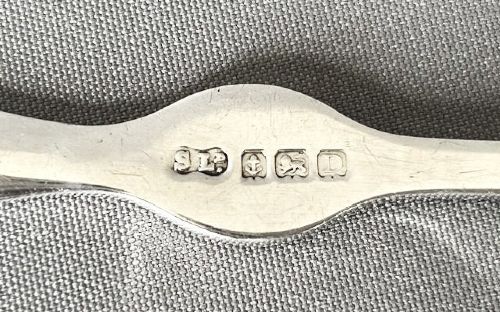 fig 1. A set of four silver crab picks arranged inside a navy velvet and white silk lined burgundy presentation box.