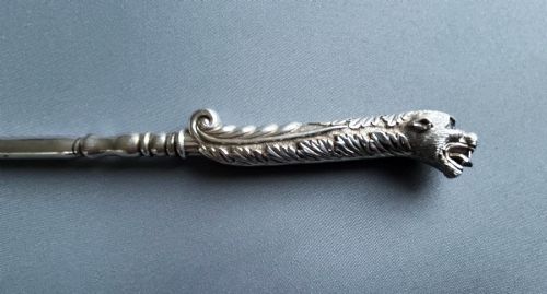 fig 1. A Victorian silver toasting fork featuring a three-tined head with a pierced trefoil design, a slender stem, and a handle sculpted as a panther head.