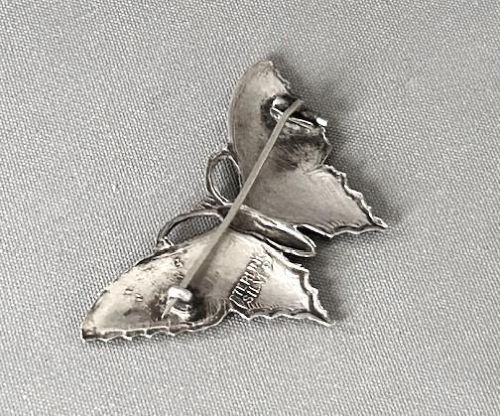 A silver butterfly brooch crafted with vibrant blue and yellow translucent enamel over textured wings. View V