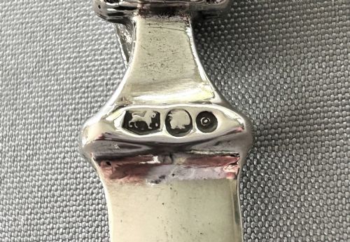 fig 1. A silver letter opener featuring a finely cast owl handle above a polished blade engraved with script text.