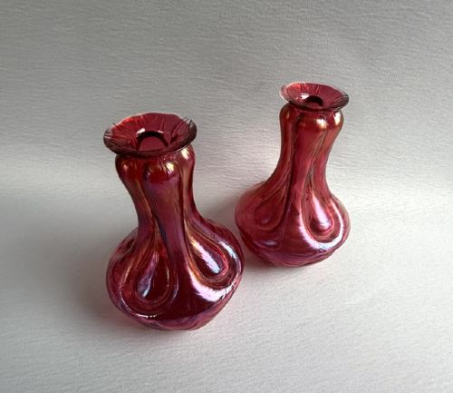 fig 1. A pair of Art Nouveau hand-blown glass stem vases featuring a bulbous lobed design with a magenta and golden iridescent finish.