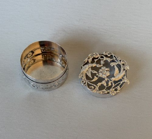 A circular Edwardian sterling silver pot pourri box with a pierced fretwork lid depicting birds and floral scrollwork. View IV