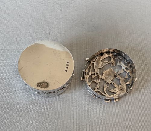 A circular Edwardian sterling silver pot pourri box with a pierced fretwork lid depicting birds and floral scrollwork. View VI