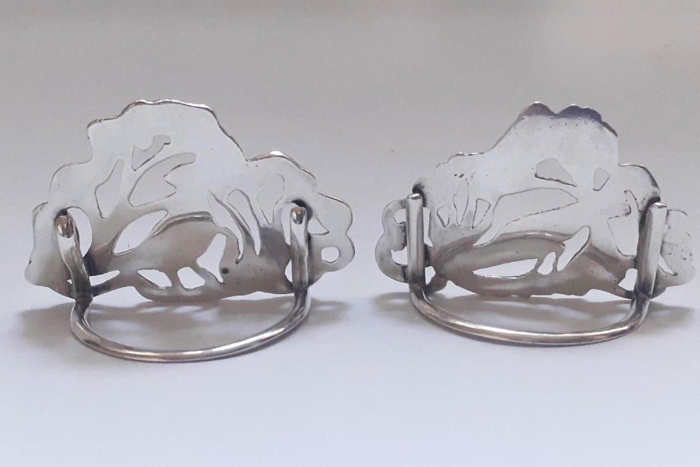 A pair of Victorian pierced sterling silver menu card holders featuring detailed bird and botanical foliage designs. View VIII