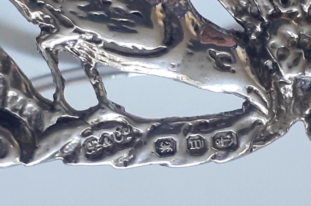 A pair of Victorian pierced sterling silver menu card holders featuring detailed bird and botanical foliage designs. View X