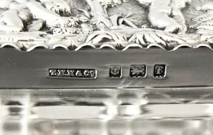 An Edwardian rectangular cut glass double stamp box featuring an embossed sterling silver lid decorated with classical cherub figures. View VI