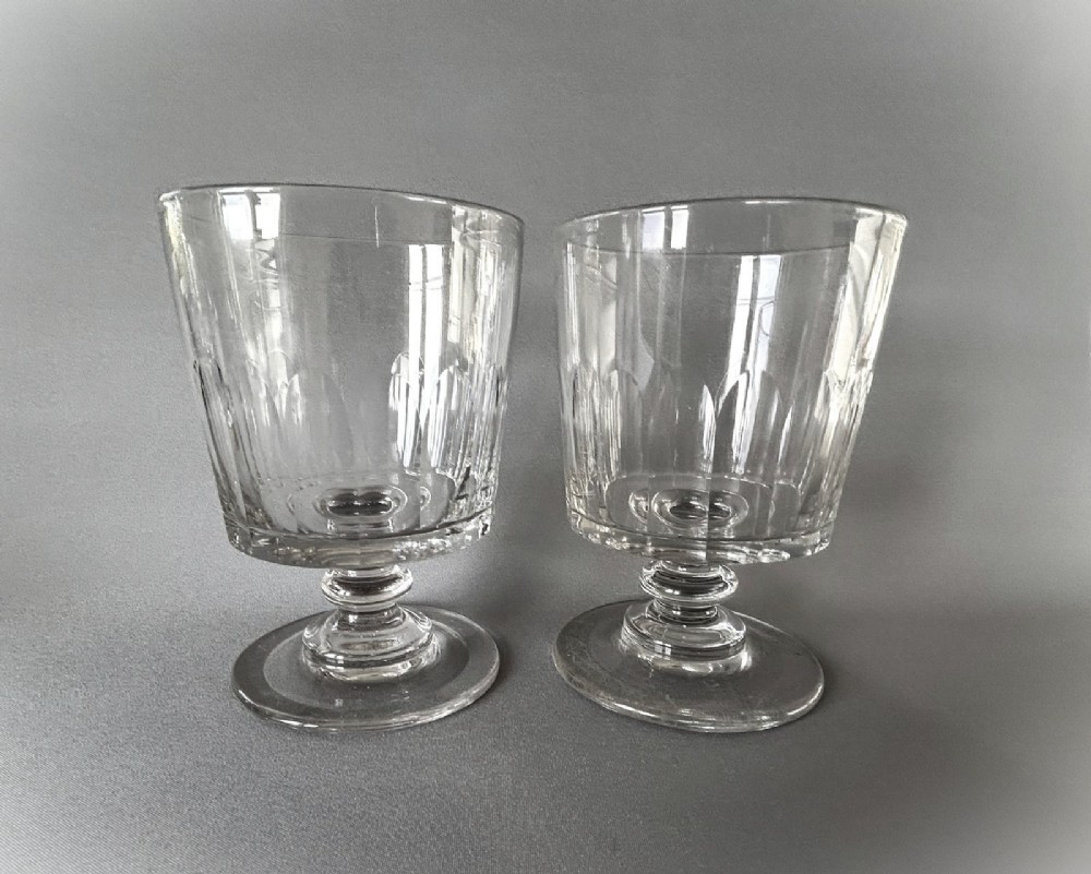 A pair of clear glass Georgian rummers featuring cut fluted bowls, knopped stems, and flat circular bases. View V