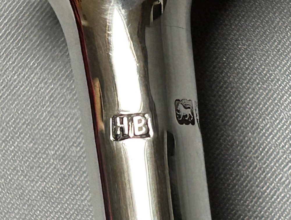 A Victorian sterling silver candle snuffer fashioned in the shape of a long, tapered hunting horn with a flared mouth. View II
